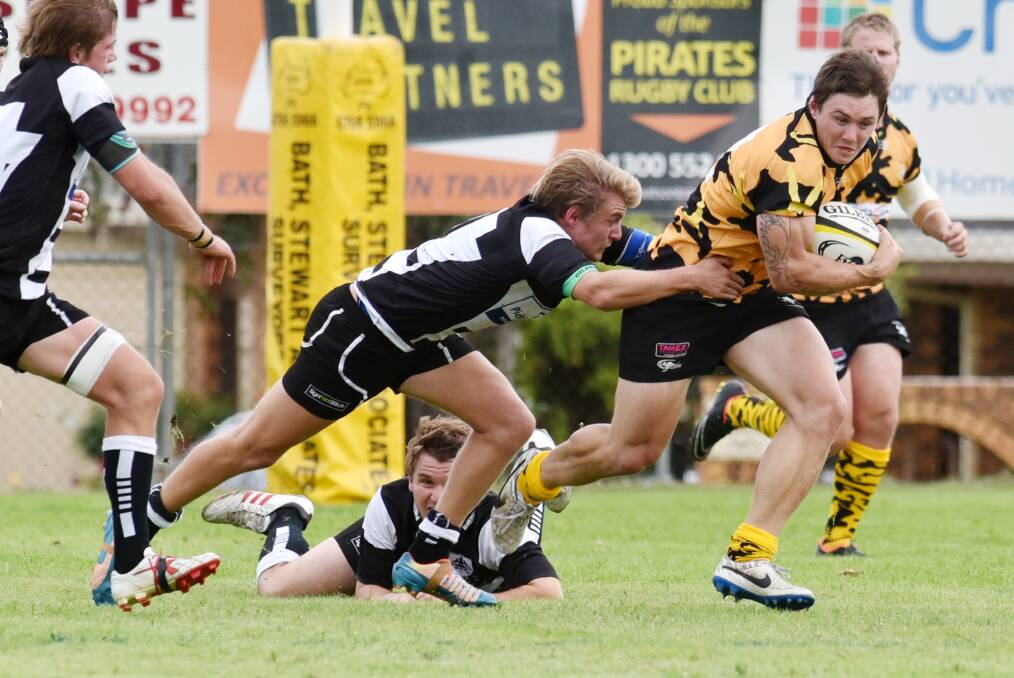 Tamworth half-back Nick Humphries clings to Pirates centre Jake Douglas after he slips Adam Penman’s attempted tackle. He polled the three best and fairest points and will next weekend be a key cog for Central North at the Country Championships.  Photo: Geoff O’Neill 180415GOG06