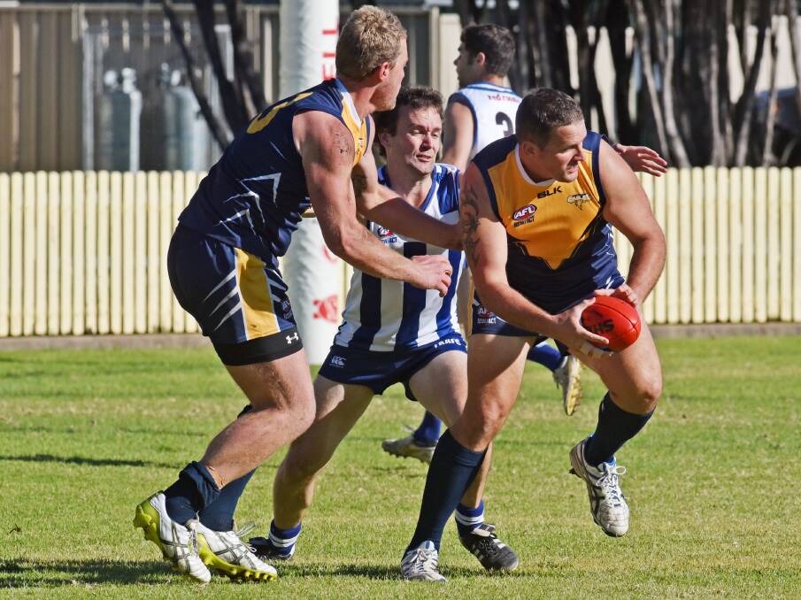 Narrabri Eagles’ Daniel Hughes looks for an opportunity as Roo Robbie Sizer takes a hand. Todd Fagan (left) also helps out in Saturday’s big win for the Roos. Photo: Geoff O’Neill 270615GOD05