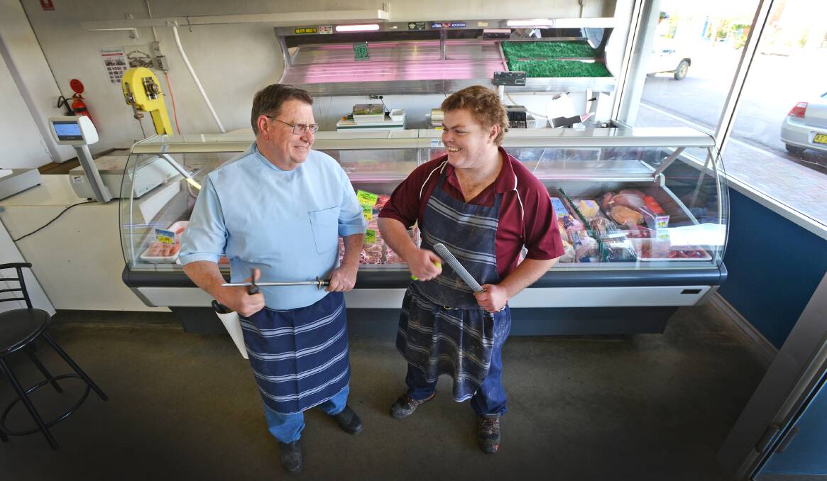 END OF AN ERA: Retiring butcher Peter Hancock shows new owner Ben Freeman, 25,  the ropes as Barraba’s iconic CR Hancock & Sons butchery changes hands. 
Photo: Barry Smith 010914BSB02