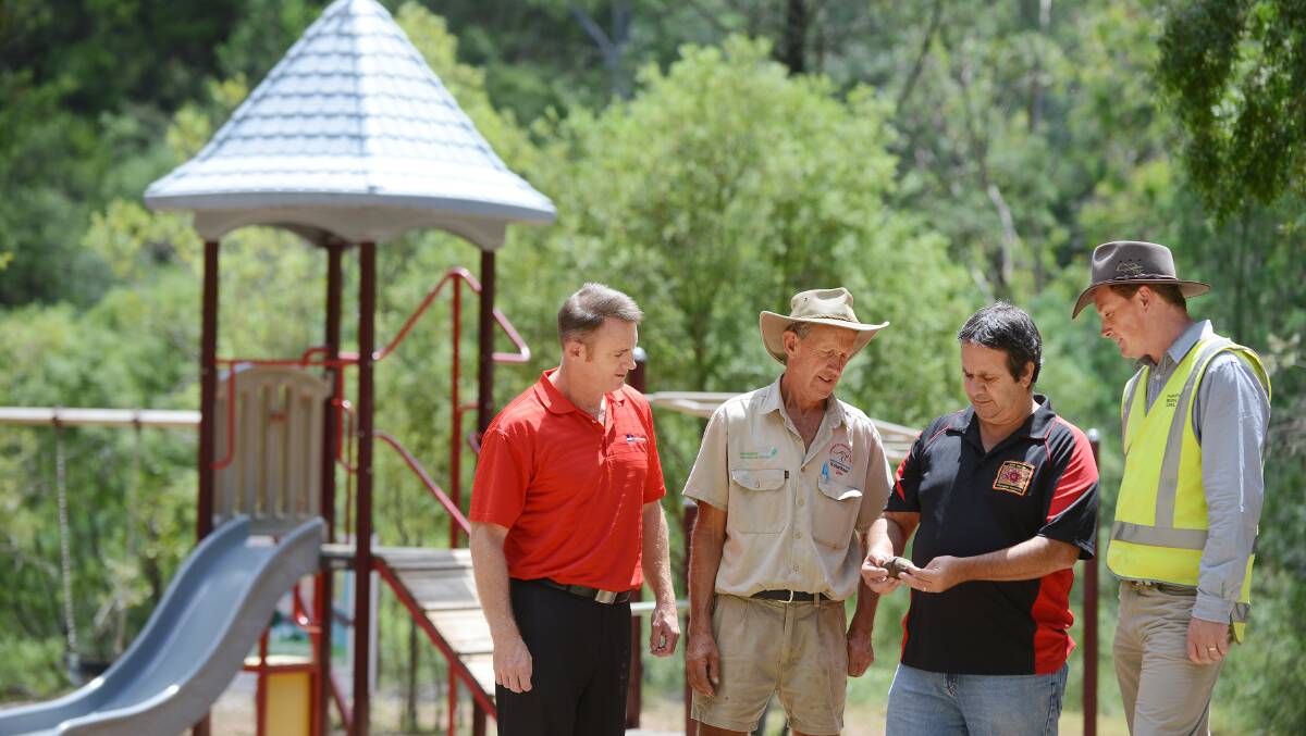 SIGNIFICANT MOVE: Examining one of the Aboriginal artefacts found at the Marsupial Park are, from left, Charles Impey, John McDarmont, Barry Cain and Hugh Leckie. Photo: Barry Smith 170215BSF04