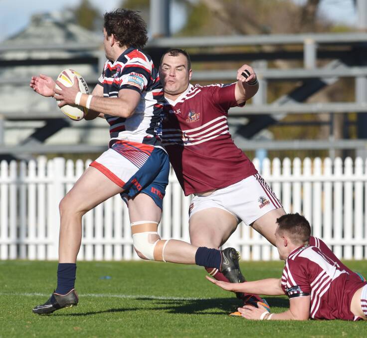 Gunnedah’s Aaron Donnelly gets wrapped up by West’s Chris Vidler on Sunday at Scully Park with Will Chesterfield going for the ankle tap. Photo: Barry Smith 210615BSE26