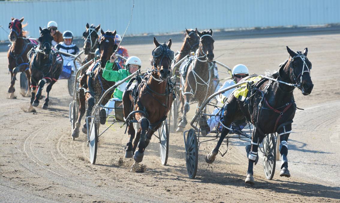 Lola Weidemann and Bulldust are about to pounce on Anthony Varga and No Confession to win yesterday’s second race at Tamworth Paceway. It was part of a winning treble for Lola and her sister Julie. Photo: Barry Smith 020715BSE01