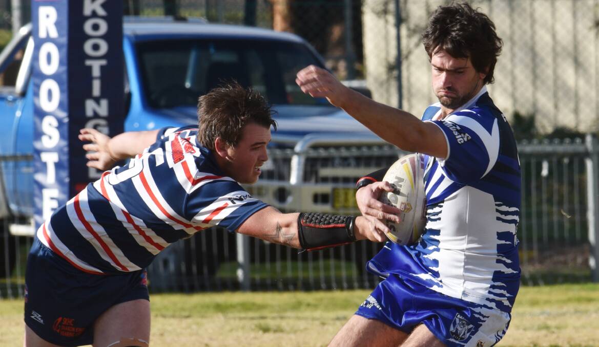 Barraba’s Zac Mallise tries to elude the clutches of Rooster five-eighth Jordan Sharpe last Saturday. This Saturday Mallise and his Bulldog teammates will be hoping to beat the 
Boggabri Kangaroos at home while Jordan and his Rooster mates head to Werris Creek to tackle the Magpies in a big top-of-the-table clash. Photo: Geoff O’Neill 110715GOB04