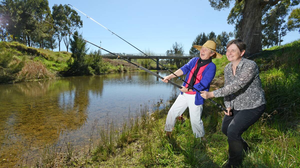READY TO CATCH: Upper Peel Landcare Group members Kay Deaves and Karlee Burgess readying their rods for the Nundle to Chaffey Dam Carp Muster on the Peel River. Photo: Barry Smith 120914BSB03