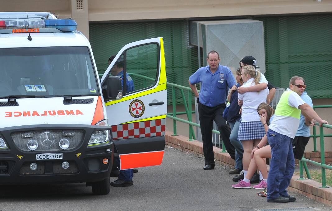 LEFT – DISTRESS: Family, friends and staff console one another outside Tamworth High School after a 14-year-old boy suffered chemical burns following a science 
experiment gone wrong yesterday. 