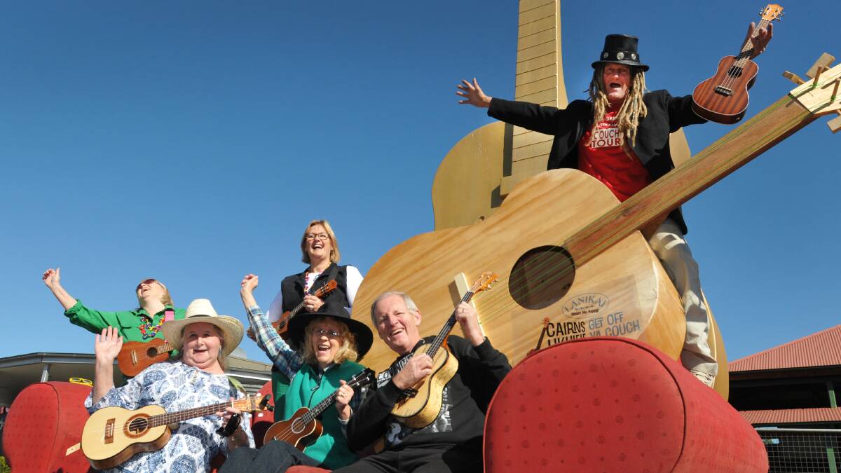 IN TUNE: Front from left, Jennifer Richards, Lynette Andersen and Peter Harkins, with Lea Lobban and Linley Manning, back, joined the Living Poet, Michael Jones, when a travelling ukulele pulled up stumps at the Big Golden Guitar yesterday. Photo: Geoff O’Neill 050614GOC01 