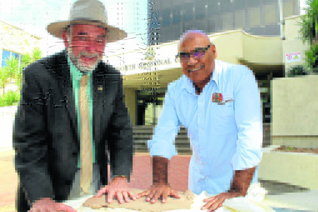 ROCK SOLID: Acting mayor Russell Webb and Aboriginal community consultative committee chairman Harry Cutmore make an imprint in clay ahead of National Reconcillation Week.