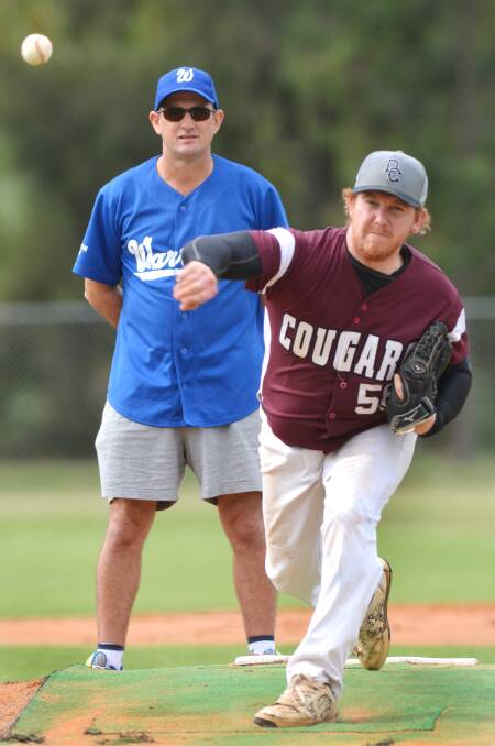 Cougars’ Kris Bird pitches for his side in a trial match last Saturday as Warriors stalwart Robert Chandler umpires. The competition starts tomorrow. Photo: Barry Smith 260414BSC10
