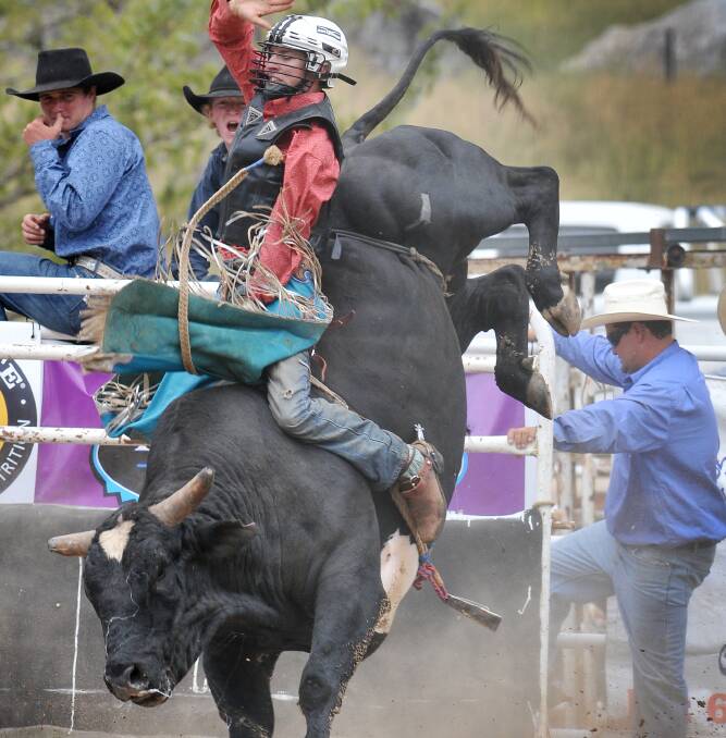 HANGING ON: Tamworth’s Brady Gray kicks out in the Bendy bull ride.
Photo: Gareth Gardner 160214GGD06