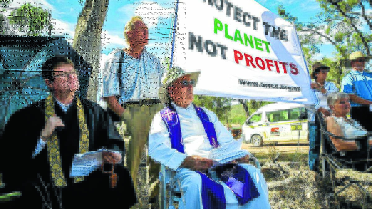 HELP FROM ON HIGH: From left, Newcastle-based Buddhist chaplain Gregg Heathcote, local ecologist Phil Spark and Armidale priest Father Ron Perrett pray for a stop to the Maules Creek coalmine.