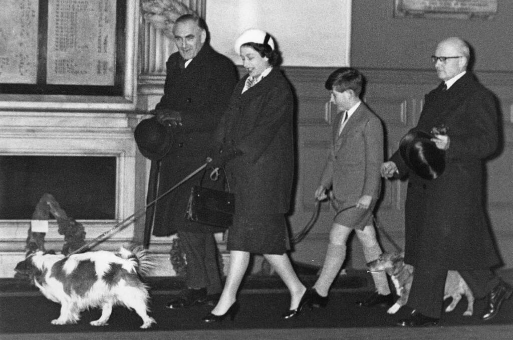 Queen Elizabeth II and Prince Charles walk through Liverpool Street Station in London with their dogs, having returned by train from Sandringham after the Christmas holidays, 18th January 1960. The Queen is expecting the birth of her son Prince Andrew in one month's time. Pic: Derek Berwin/Fox Photos/Getty Images