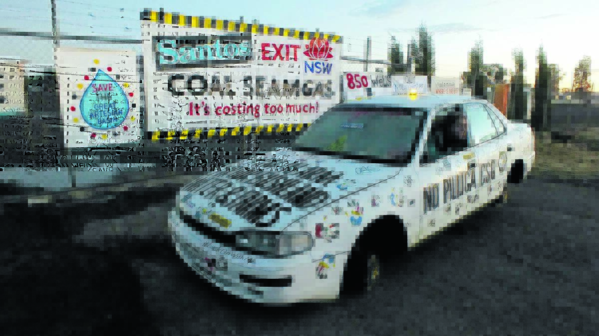 WHEELS OFF: Protester Namoi Tarrant leans out of the cement-laden car outside the Santos site.