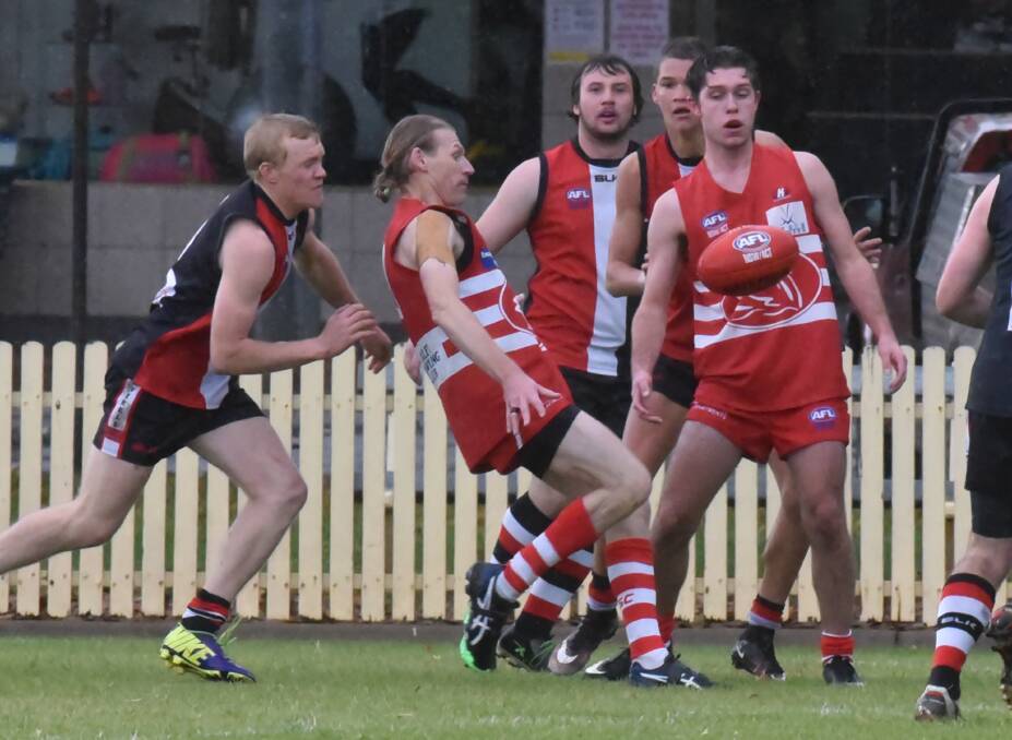 Dean Finlay kicks the Swans out of trouble against Inverell Saints on Saturday (from left) Finlay,  Beau Coles (Saints), Brennan Cosgrove (Saints) and  Harrison Tibbles (Swans). Photo: Geoff O’Neill 280516GOE02