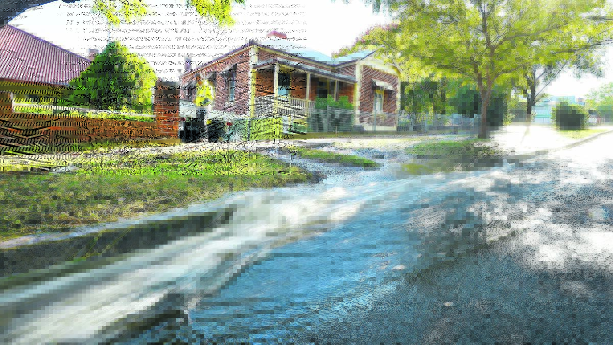 FAST FLOW: Darling Street’s drains couldn’t contain the torrent from a broken pipe yesterday. Photo: Barry Smith 300516BSA19