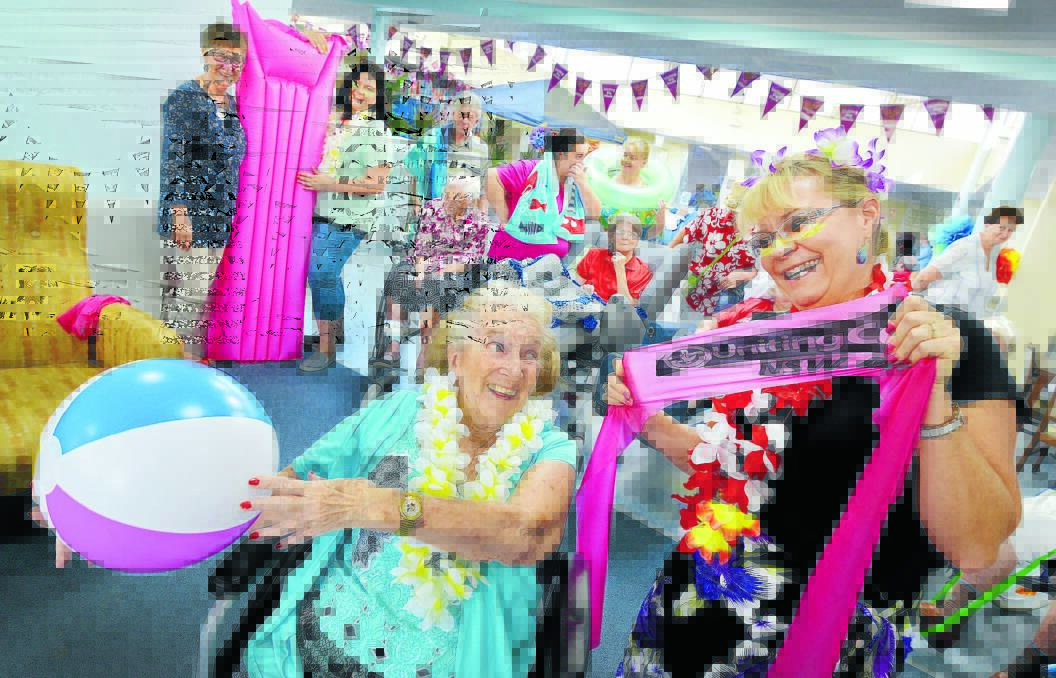 SURF’S UP: McKay House resident Janet Evans with administration officer Lee-Anne Ferris having some fun ahead of the dance for dementia. Photo: Barry Smith 310316BSB02