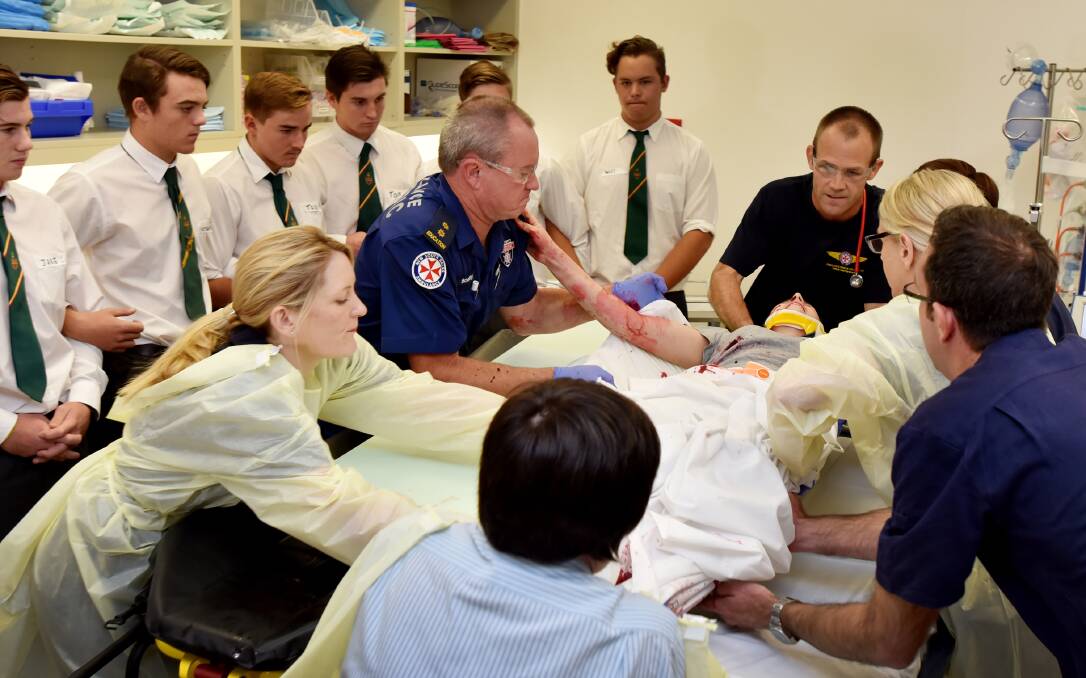 HORRIFIC CONSEQUENCES: Students watch on as staff play out the scenario of a trauma patient in the ED. Photo: Geoff O’Neill 050516GOB04