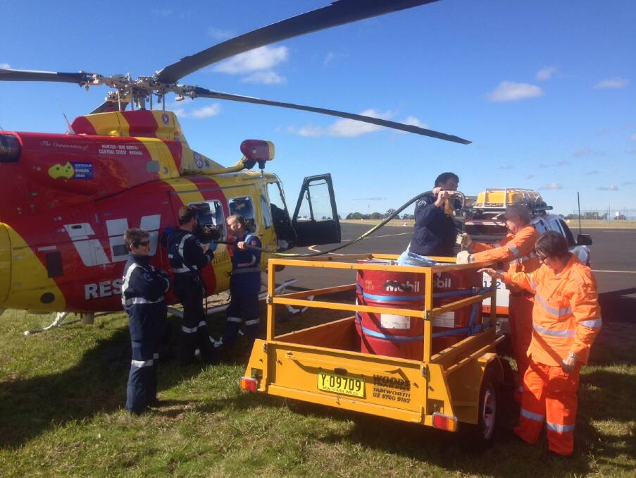LENGTHY OPERATION: SES volunteers help to refuel the Westpac Rescue Helicopter at the Coonabarabran airport. Photo: Westpac Rescue Helicopter
