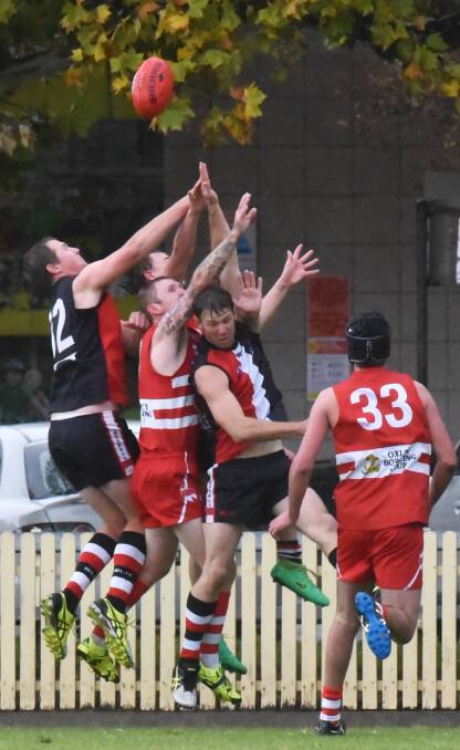 Swans and Saints fly for this mark (from left) Sam Kimmence (Saints), Andrew Schnedier (Saints obscured), Barry Morgan (Swans), Adrian Cox (Saints), while Swan Jayden Kennedy (33) runs to grab the scraps. Photo: Geoff O’Neill  80516GOE01