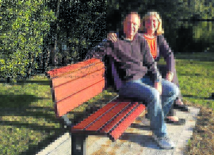 Jim Wesley’s son and daughter-in-law, Michael and Gill Wesley, sit on the memorial seat by the banks of the Lansdowne River.