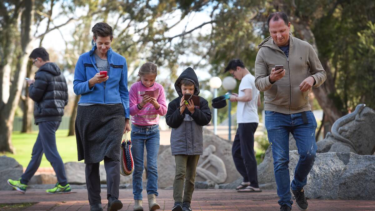 FAMILY FUN: From left: Kate Jefferay, Anouk, Ozzy and  Phil Brown were visiting from Brisbane and joined hoards of people hunting Pokemon in Bicentennial Park. Photo: Gareth Gardner 110716GGC05