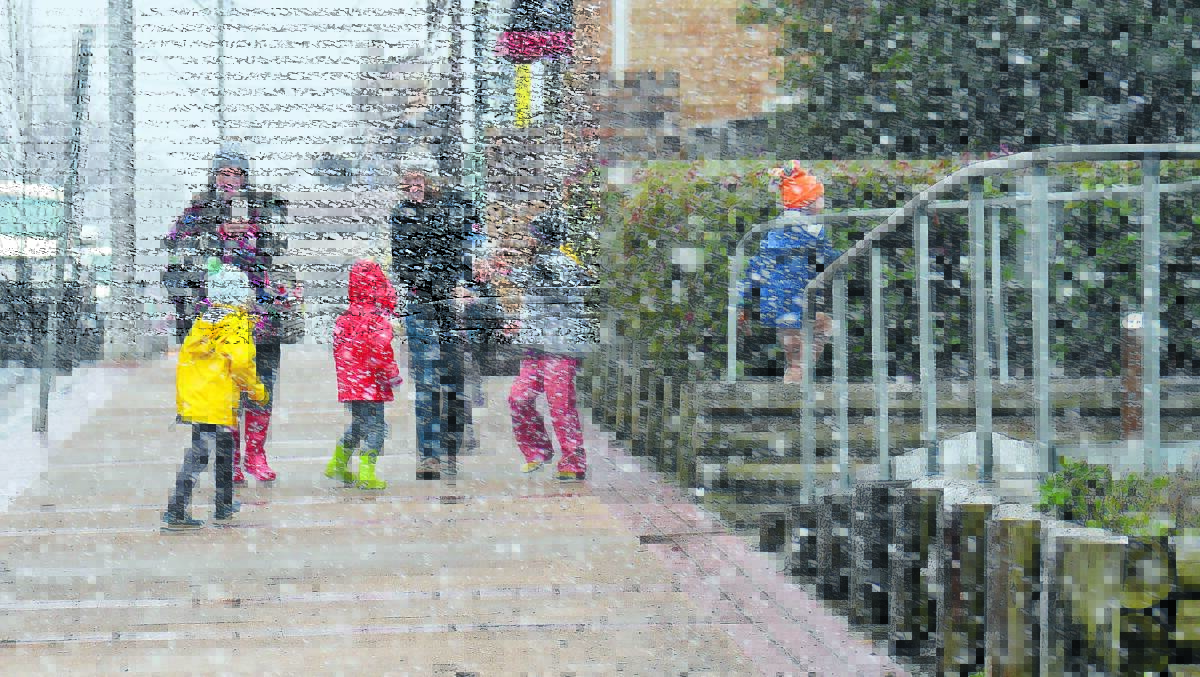 Visitors from Bellingen enjoy blizzard-like conditions in Guyra yesterday. Photo: Janelle Stewart