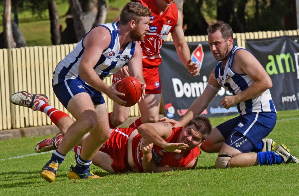 Tamworth Swans’ best Sam Roberts is on he ground as he tries to stop another Roos attack headed by Ben Evenis (ball) and Daniel Overeem (right) at No1 Oval on Saturday. The Roos won the local derby by 119 points. Photo: Geoff O’Neill 070516GOC07