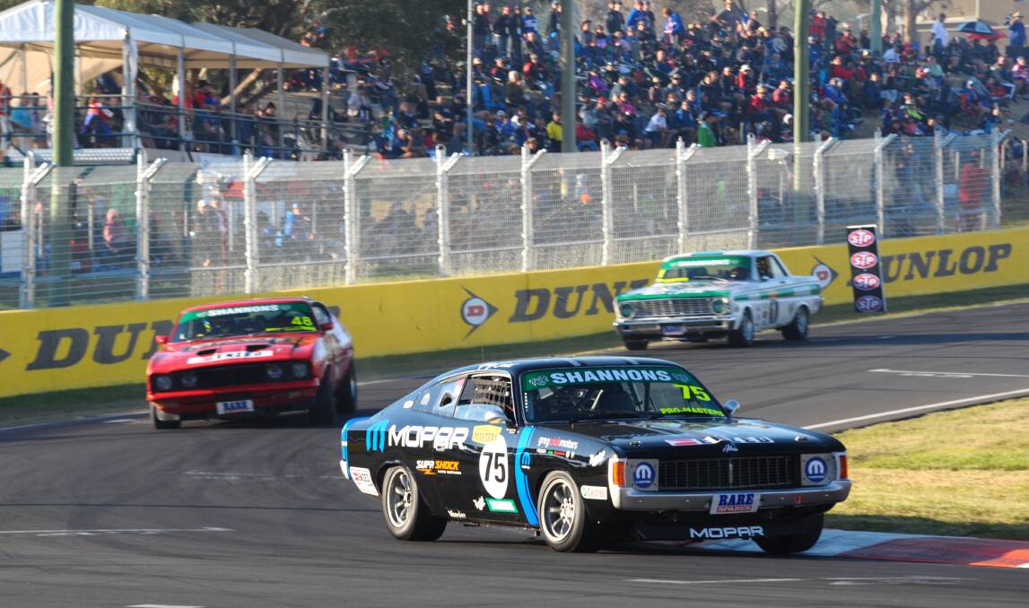 FINAL MOMENTS: Greg Crick leads the way to the chequered flag in this morning’s Touring Car Masters race with Kim Jane and Jim Richards following. Photo: ZENIO LAPKA 	101214zmuscle2