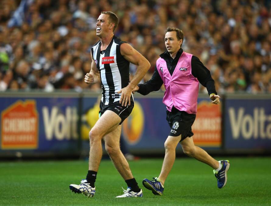 Nick Maxwell of the Magpies is helped from the ground by a trainer at the MCG. Geelong ran out 87 points to Collingwood's 76. Picture: Getty Images