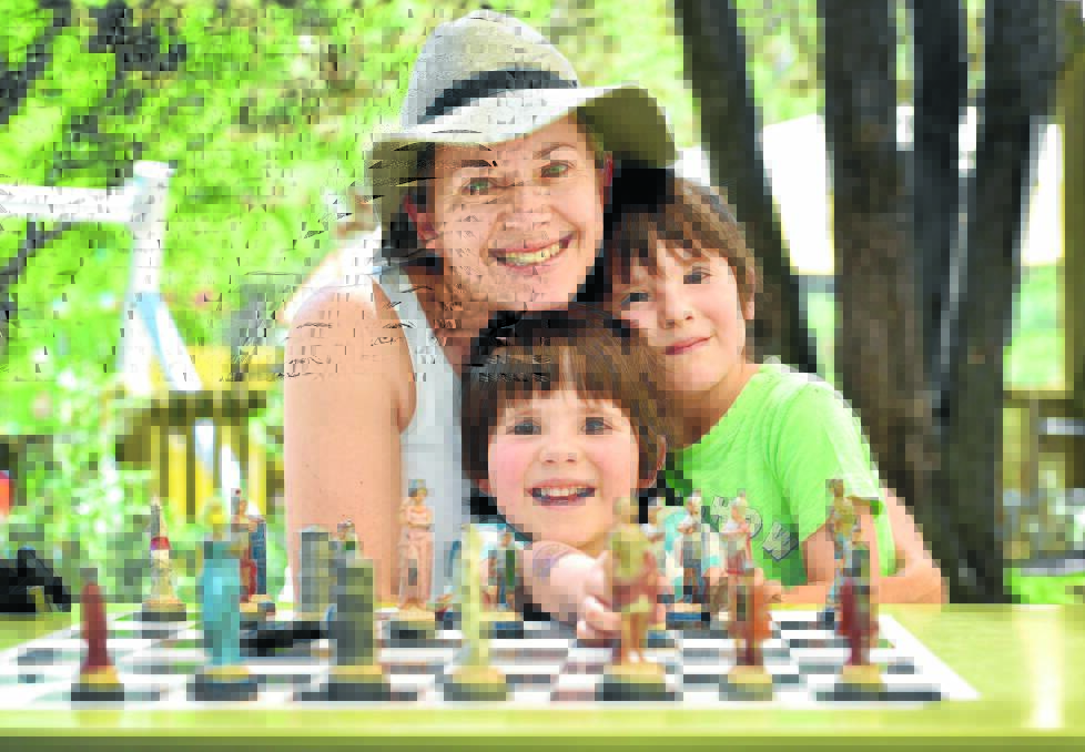 CHECKMATE: Teree Burr of Nundle enjoys a game of chess with twin sons Max and Alex, 5, at the Marsupial Park. Photo: Geoff O’Neill 051015GOA04