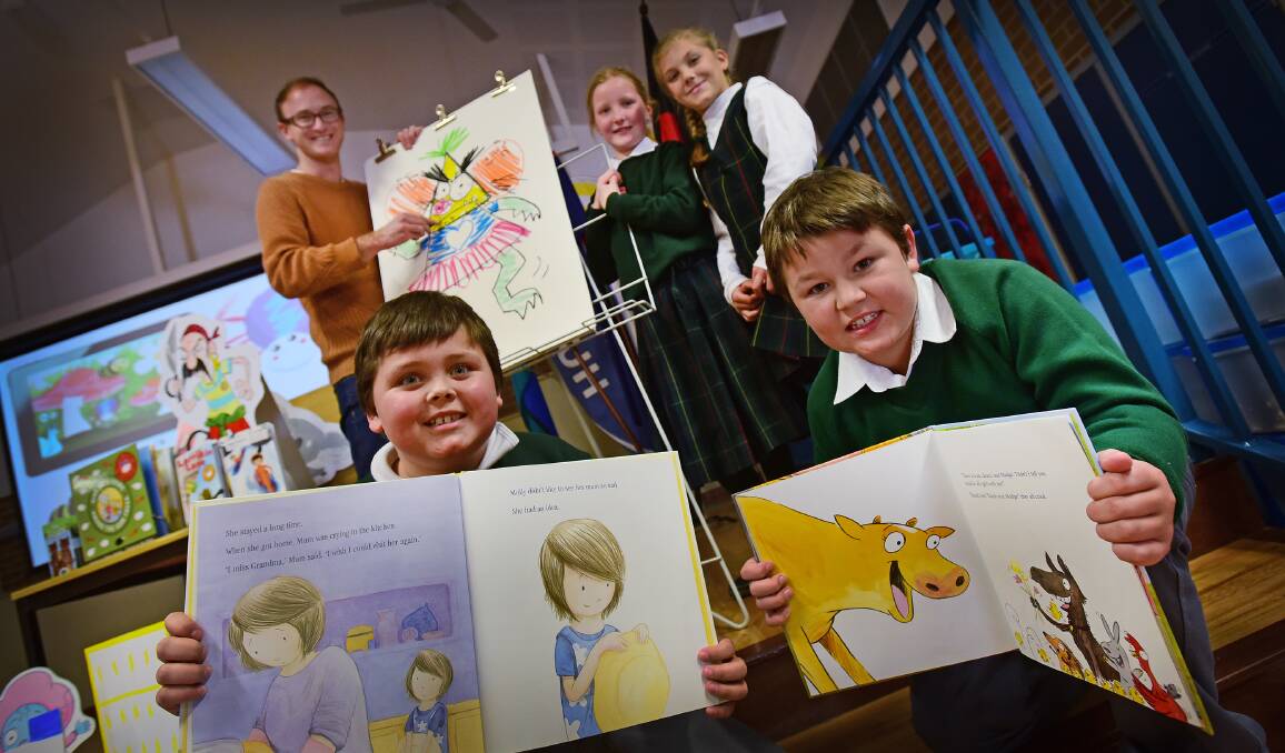 WORDS AND PICTURES: Illustrator Ben Woods with Hollie Schlenert and Simone Greatbatch. At front, Ethan Cain and Tyson Barnes with some of Mr Wood’s illustrations in books. Photo: Gareth Gardner 270715GGD04