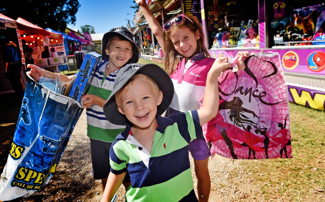 PHOTO – IT’S IN THE BAG: From left, Brock (5), Declan (3) and Alyvia Wilson (7), all of Tamworth, in sideshow alley on Saturday. Photo: Geoff O’Neill 140315GOA11