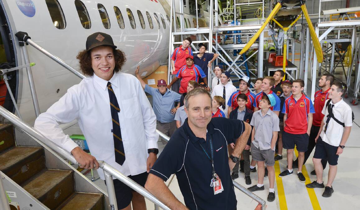 CAREER PATH: Oxley High School and Clontarf Academy student Tom Hammond was the tour guide for classmates and airline executives, including chief engineer Alastair Prout, at the QantasLink hangar. Photo: Barry Smith 020915BSB02