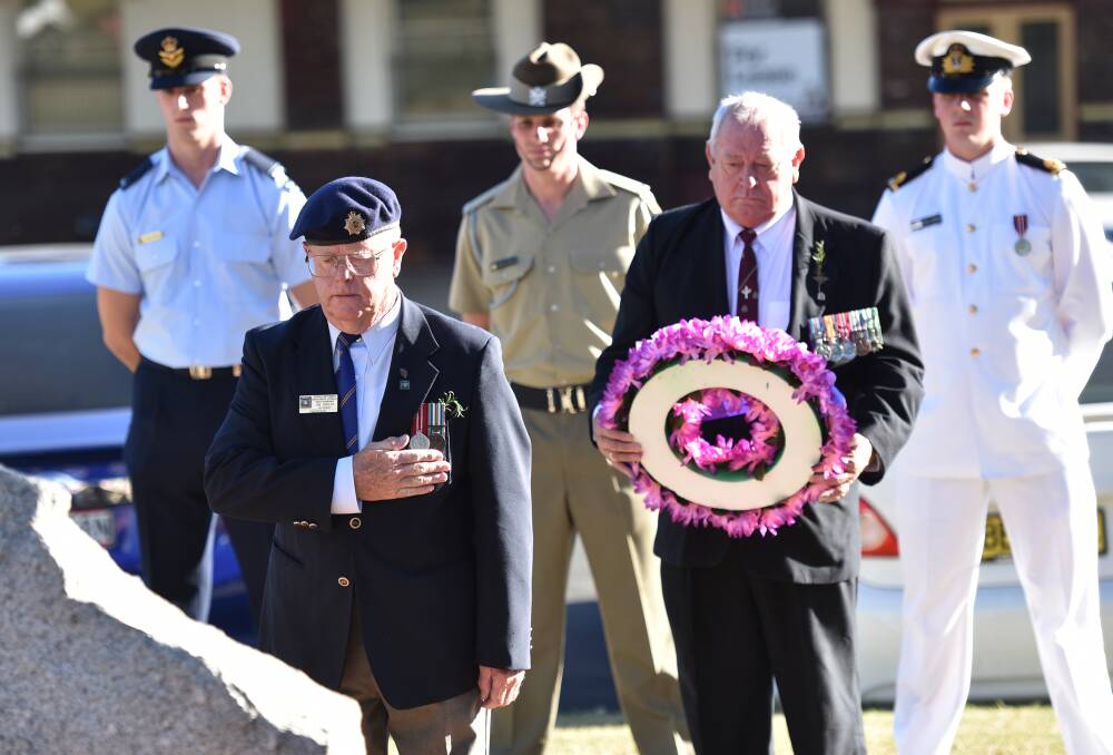 IN REMEMBRANCE: National Servicemen’s Association Oxley Sub-branch president Jim Jordan salutes after laying his wreath as Vietnam War veteran Dave Fanker prepares to lay his floral tribute. 
Photo: Geoff O’Neill 280315GOH04