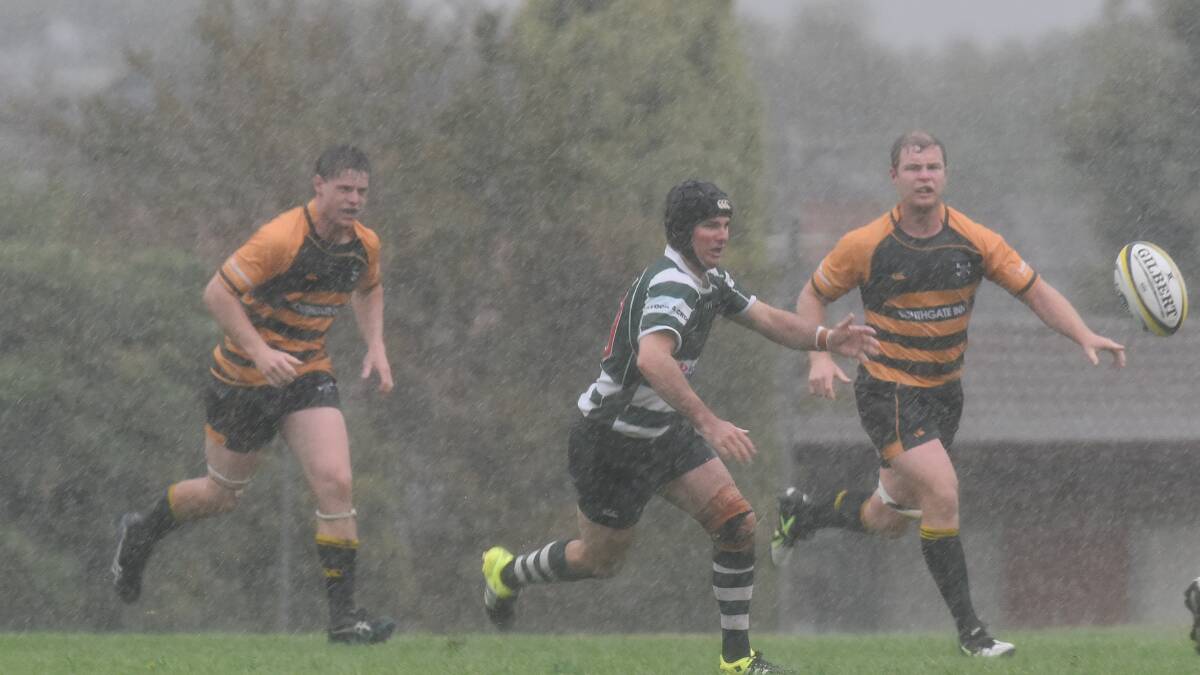 Barraba five-eighth Ben Withers tries to drive his side on in the driving rain as Pirates’ Billy Hartmann (left) and Andrew Wynne race up.  Photo: Gareth Gardner 300416GGH04