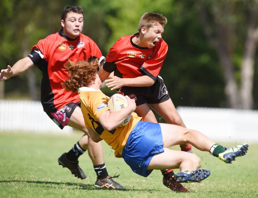 Tamworth’s Fritz Schneider tackles Denman’s Tom Pickersgill as Gunnedah’s Bailey Lennox looks on during one of the GNA trials at Jack Woolaston Oval on Saturday. Photo: Barry Smith 101015BSH22