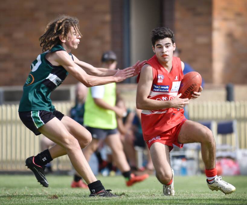 Tyros (from left) Thomas Lashlie (Nomads) and Alex Stuart (Swans) lock horns in Saturday’s TAFL clash. The Nomads won by 109 points at No 1 Oval.  Photo: Barry Smith 160416BSB04