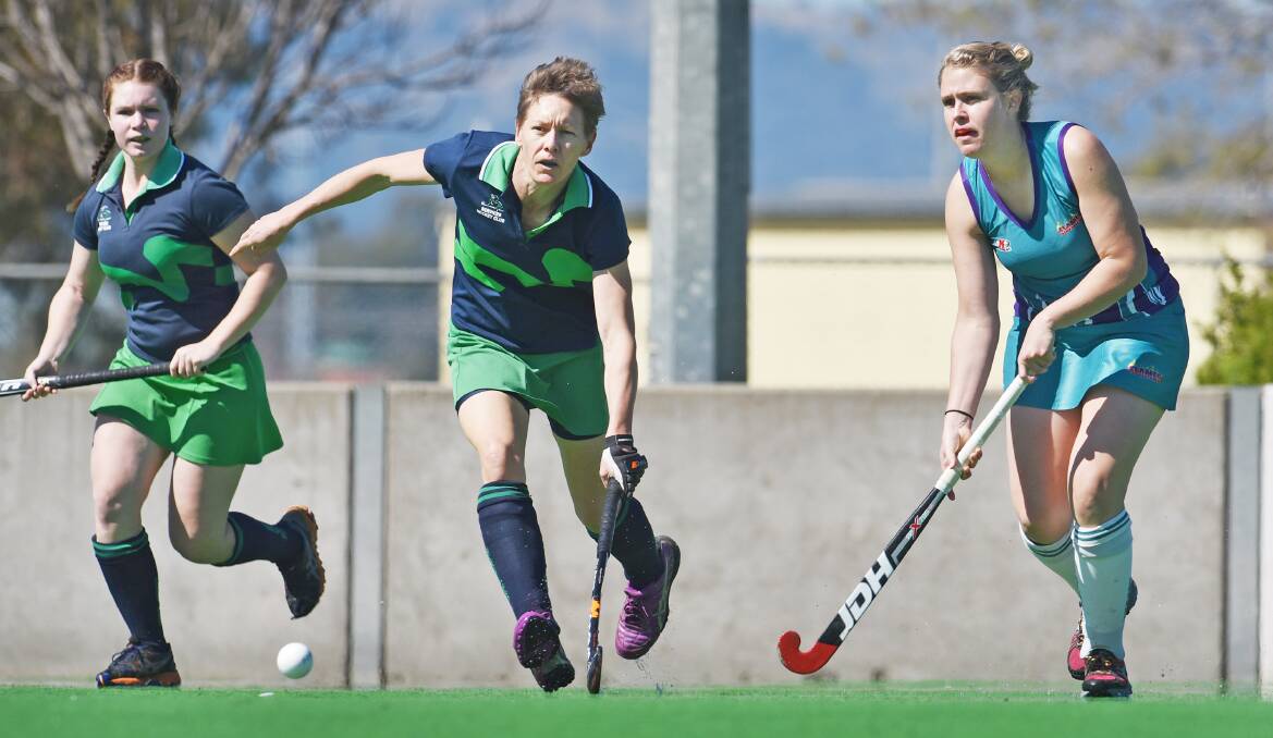 Services’  Kate Perrett (centre)  and Flames’ Ashley Allen follow the ball during Sunday’s minor semi-final as Services’  Tessa Pennefather looks on.  Photo: Barry Smith 300815BSC04