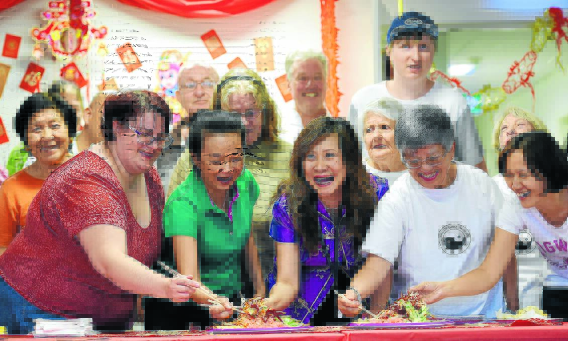 MONKEY BUSINESS: Revellers tossing the traditional prosperity salad at Chinese new year celebrations at Centacare on Friday – front, Jessica Lane, Kitty Khoo, event organiser Suelyn Pakes, Janita Ying and Sun Lee.  Photo: Gareth Gardner 120216GGC01