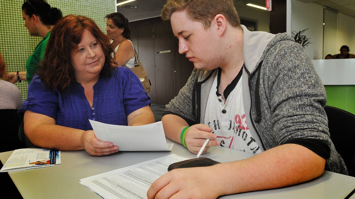 SIGNING UP: Brody Goodman, with mum Melissa Crowell, was one of dozens of students to take advantage of an open enrolment day at Tamworth TAFE on Wednesday. Photo: Geoff O’Neill 280115GOC01