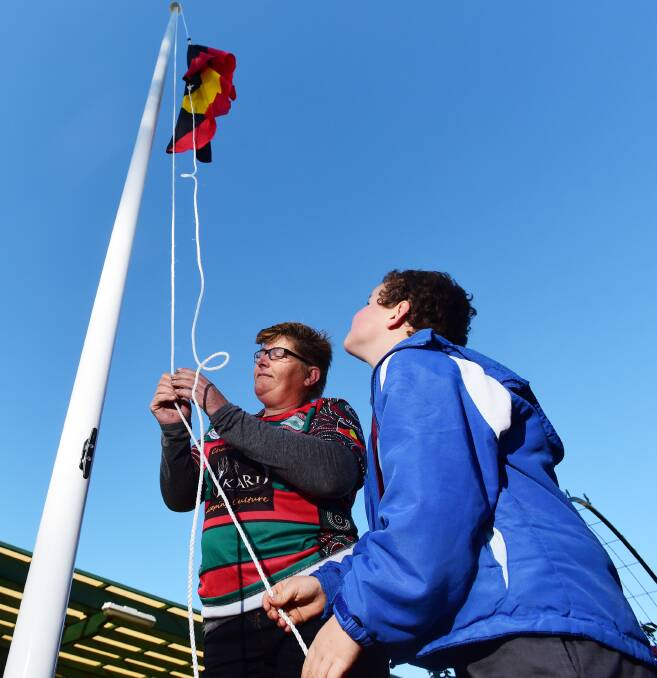 HISTORY IN THE MAKING: Somerton Public student Benny Markwick helps Pauline Beilefeld raise the Aboriginal flag at the school for the first time. 220615GGA06