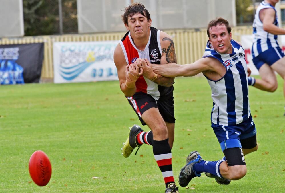Tamworth Kangaroo Justin Hathway (right) manages to knock this ball clear of Troy Dan’s hands during last Saturday’s 13- point Saint success. Today the Saints are in Moree and the Roos are in Gunnedah. Photo: Geoff O’Neill 090416GOB08