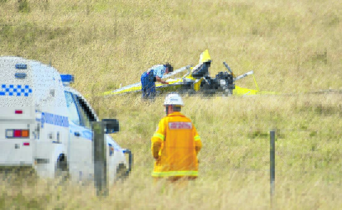 TRAGEDY STRIKES: Police investigate the site of a microlight plane crash that killed two people yesterday. Photo: Tony Grant