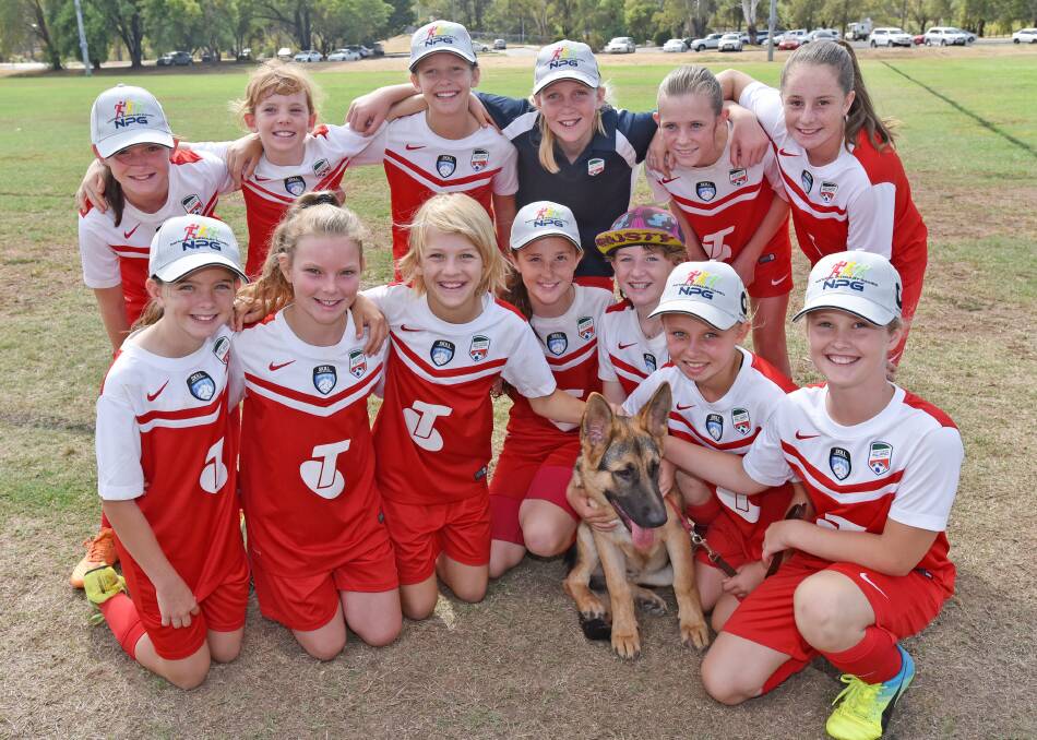 The Northern Inland football girls had a special mascot at the Primary Games over the weekend. (Back from left) Mim 
Barbara, Grunie Shephard, Leah Elton, Chloe Lincoln, Emma James, Emma Allen, (Front from left) Claire Cavallaro, Jordan Donnelly, Julia O’Mara, Nakeisha Burgess, Claire Sullivan, Alexis French, Kaysha Finlay with Bear the dog.  Photo: Geoff O'Neill 100416GOA08
