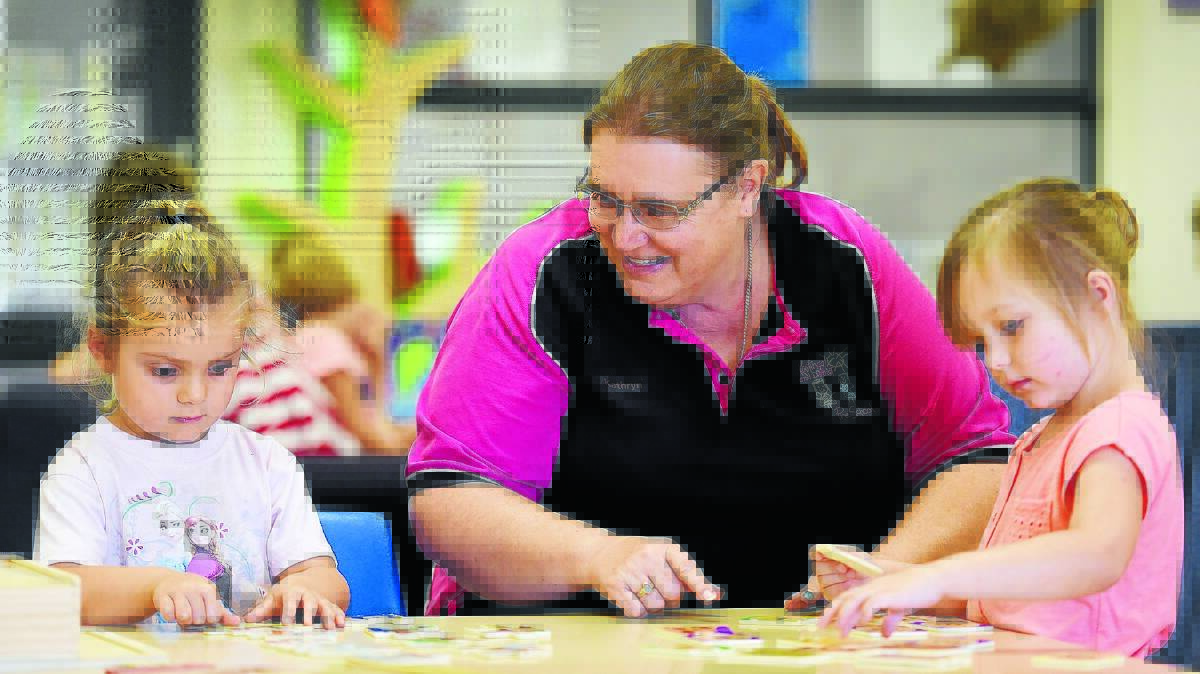 MAKING A DIFFERENCE: Kathryn Kinson works with four-year-olds Danni-ella Sullivan and Piper Hammer as the teacher celebrates being nominated for an early childhood education award. Photo: Gareth Gardner 030216GGF01