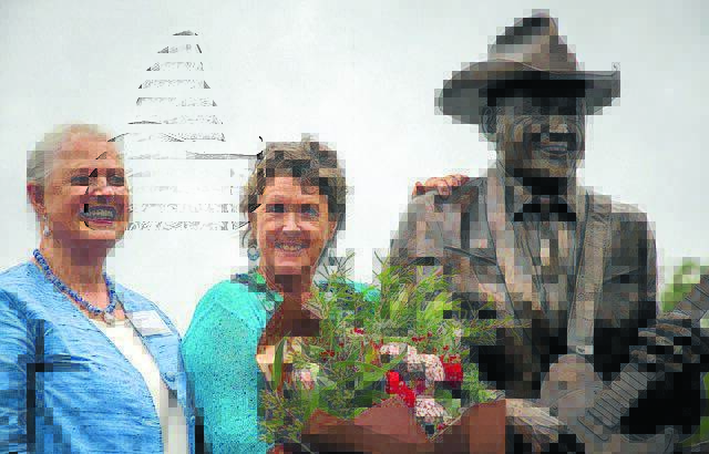 BOUQUETS: Sculptor Tessa Wallis and Ros Lindsay with the Reg Lindsay Standing Tall statue.