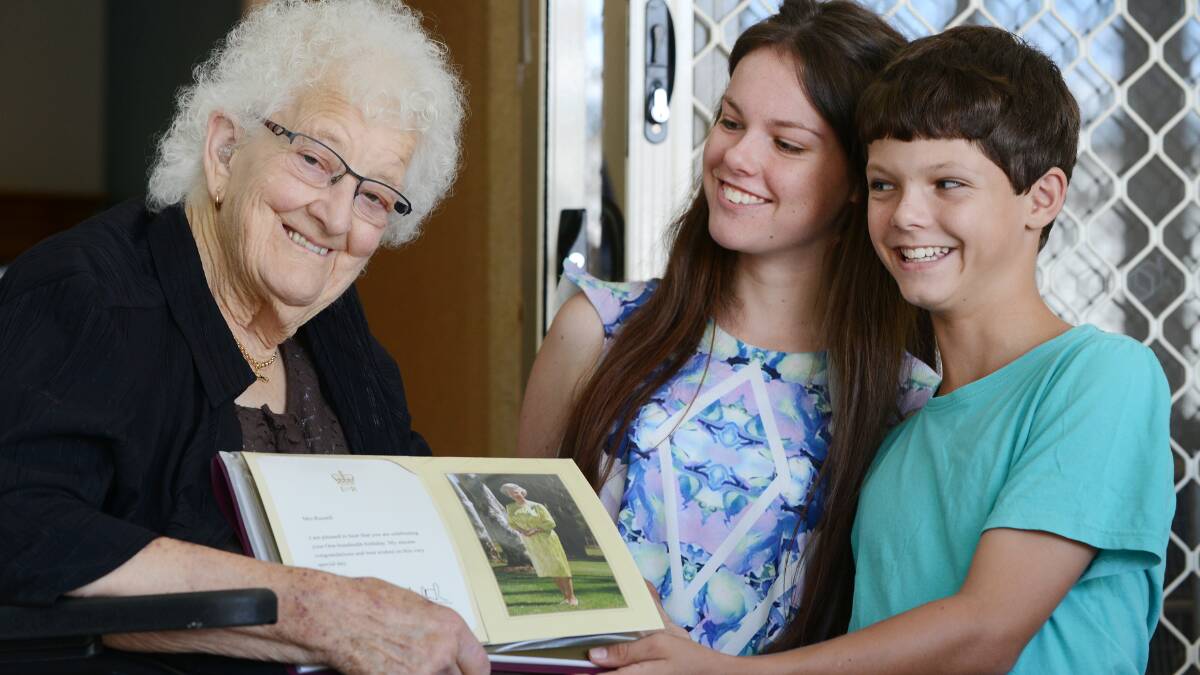A LONG LIFE: Melba Russell celebrates her 100th birthday today. She is pictured with her great grandchildren, 17-year-old Alisha and 11-year-old Lachlan Perry and her letter from the Queen. Photo: Barry Smith 270215BSA04