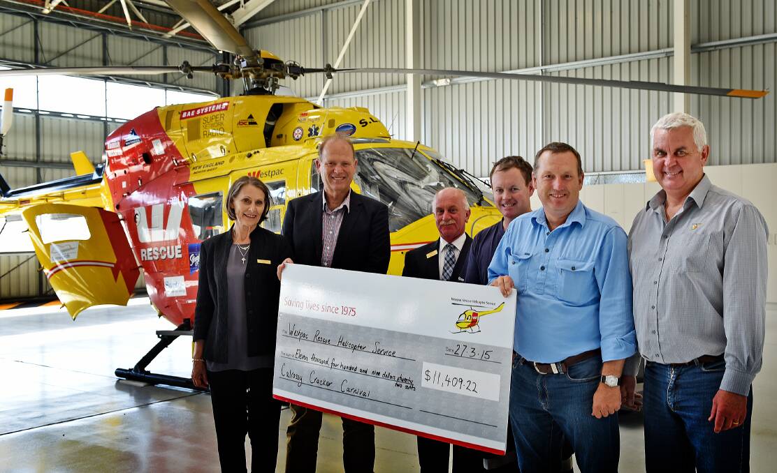 WHAT A CRACKER: Calrossy Anglican School principal Elisabeth Jackson,  head of secondary boys Joe Goldsworthy, head of primary boys Robert Black, helicopter crewman Trent Owen, P&F vice-president John Brissett and Westpac Rescue Helicopter events co-ordinator Jeff Galbraith with the whopper cheque for $11,409.22. Photo: Geoff O’Neill 270315GOD01