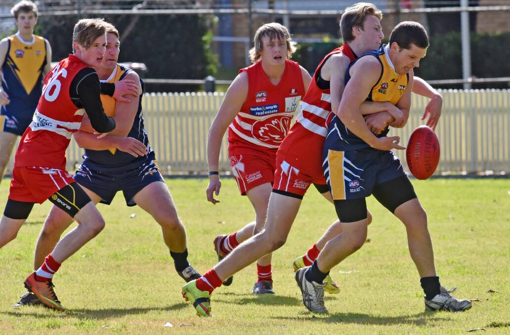 Tamworth Swans’ Jordan Jeffriess-Tapper bear-hugs Narrabri Eagles’ Matt McConnell as Maddison Smith (behind) and Thomas Kelly (Swans) and Todd Dunn (Eagles) prepare to pick up the spoils. Photo: Geoff O’Neill 010815GOB06