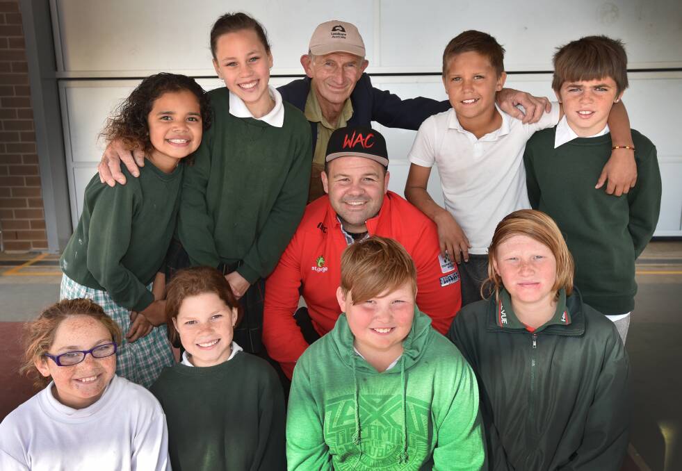 Dragons prop George Rose (centre) is swamped by Hillvue’s (back from left)  Emarni Lawrence, Hannah Towney, John Tucker (Landcare 
representative), Dawson Nean, Dremayne Turnbull, and (front from left) Chloe Bamblett, Katelyn Towney, Jackson Harpur-Rutter and Tyler Hughes during his visit to the school yesterday. Photo: Geoff O’Neill 180815GOA01
