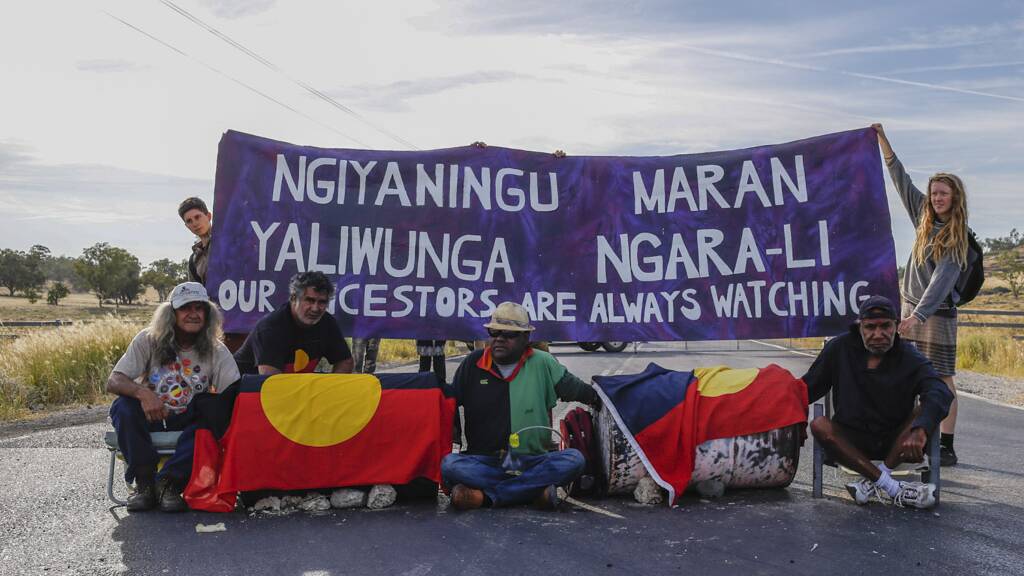 MINING PROTEST: Two Gamilaraay men and a Githabul man locked-on to concrete barrels at the entrance to the Whitehaven Maules Creek mine.